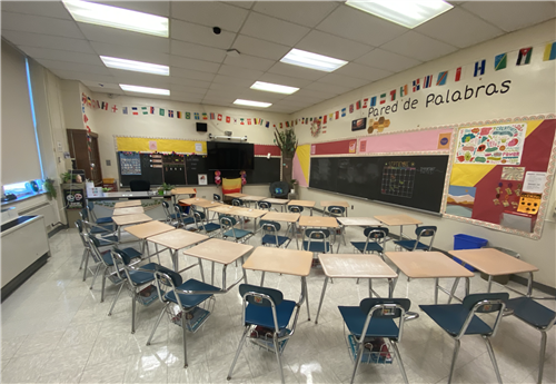 This is an image of classroom 265 before the school year starts. It has colorful paper and flags hanging from the wall!